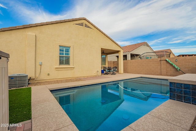 view of swimming pool with a patio area, cooling unit, a fenced in pool, and fence