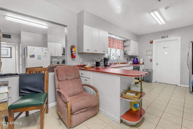 kitchen featuring visible vents, open shelves, freestanding refrigerator, and white cabinetry