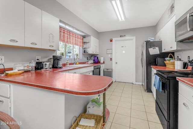 kitchen with light tile patterned floors, black appliances, a sink, and white cabinets