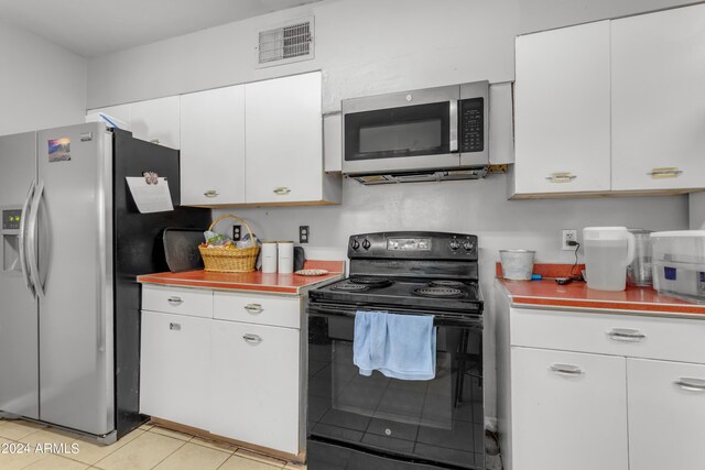 kitchen with light tile patterned floors, visible vents, white cabinets, stainless steel appliances, and light countertops