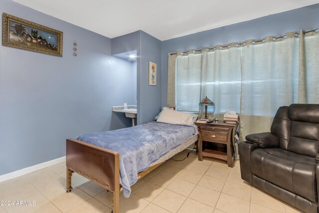 bedroom with light tile patterned floors and baseboards