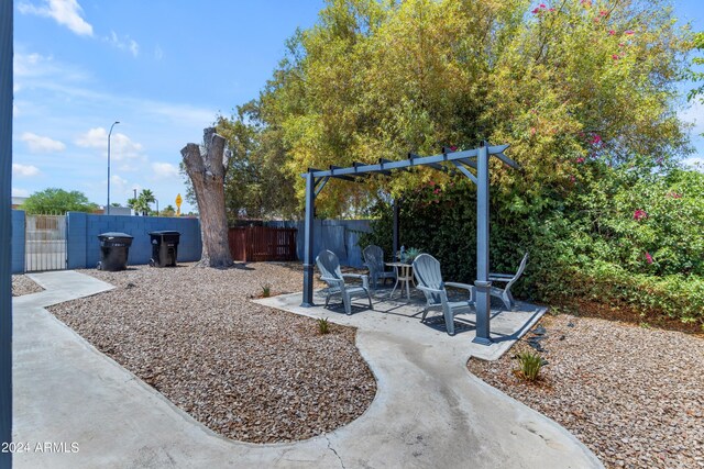 view of yard featuring an outdoor fire pit, a patio area, and fence