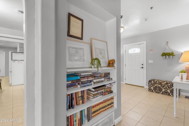 entrance foyer with light tile patterned floors and baseboards