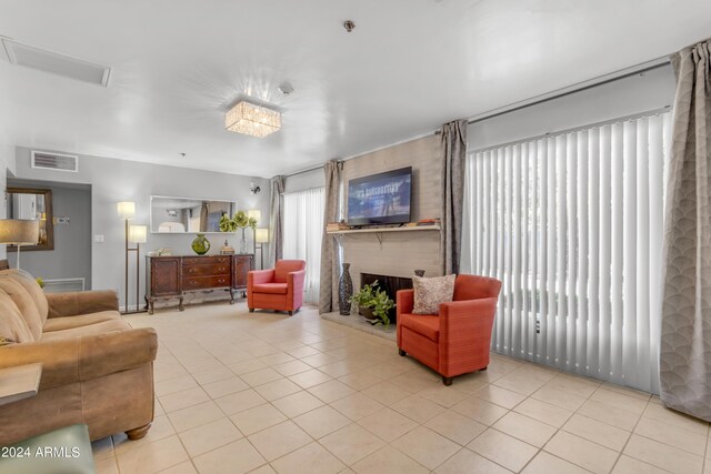 living area featuring visible vents, a fireplace, and light tile patterned floors