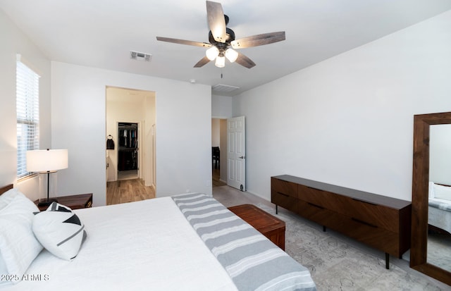 bedroom with a spacious closet, a ceiling fan, and visible vents