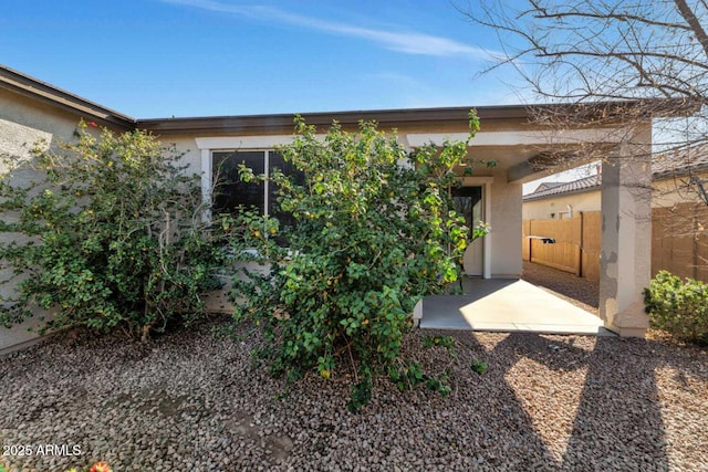 exterior space featuring fence and stucco siding