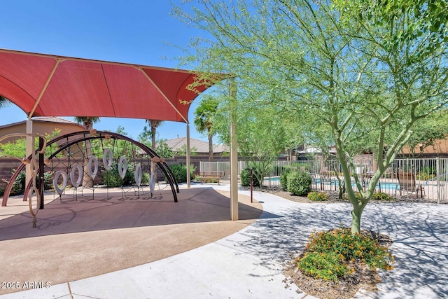 view of play area with a community pool and fence