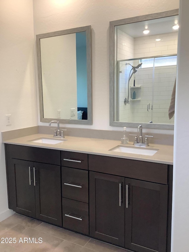 full bathroom featuring double vanity, a shower stall, tile patterned flooring, and a sink