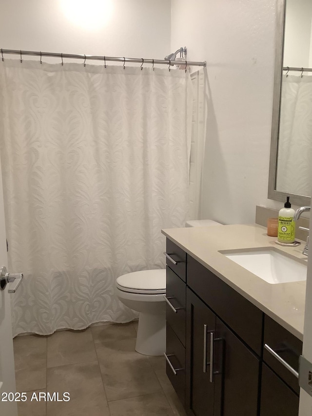 full bathroom featuring vanity, tile patterned flooring, and toilet