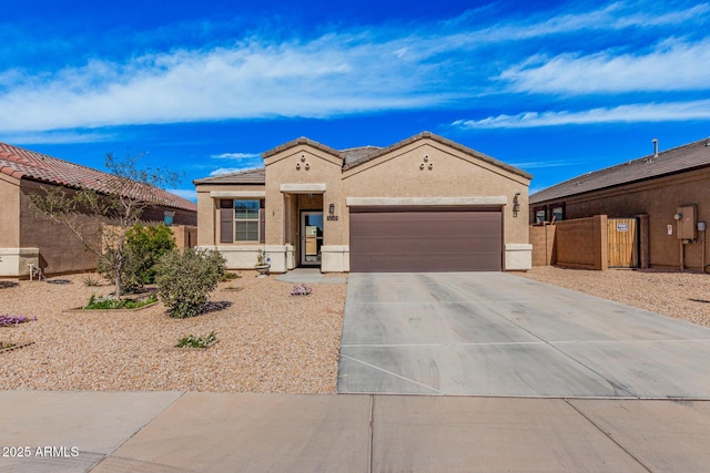 mediterranean / spanish-style home featuring a garage, a tile roof, fence, driveway, and stucco siding