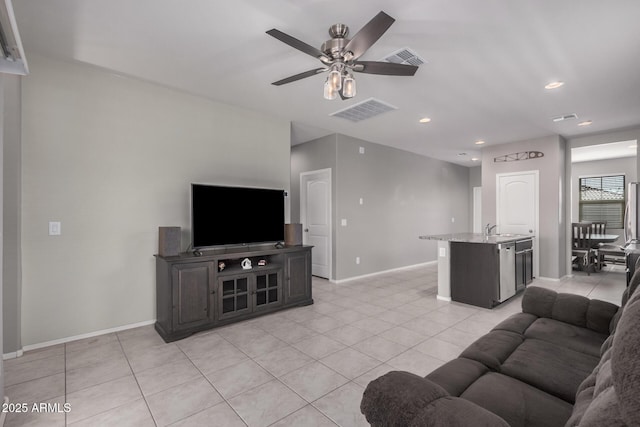 living room with a ceiling fan, visible vents, baseboards, and light tile patterned floors