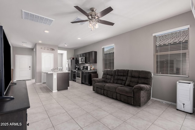 living room with light tile patterned floors, recessed lighting, visible vents, a ceiling fan, and baseboards