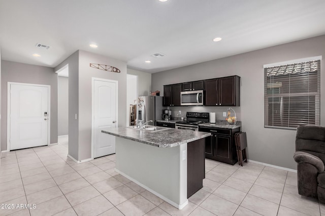 kitchen featuring stainless steel appliances, recessed lighting, visible vents, and a center island with sink