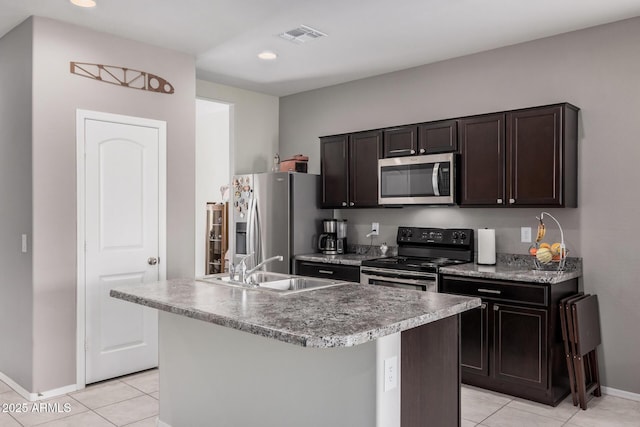 kitchen featuring stainless steel appliances, recessed lighting, a kitchen island with sink, a sink, and light tile patterned flooring