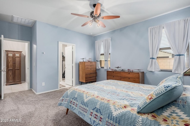 bedroom featuring a ceiling fan, visible vents, baseboards, carpet, and ensuite bath