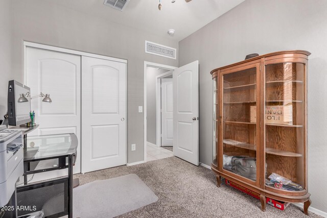 office space featuring baseboards, visible vents, and light colored carpet