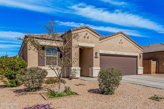 view of front of property with driveway, an attached garage, a tiled roof, and stucco siding