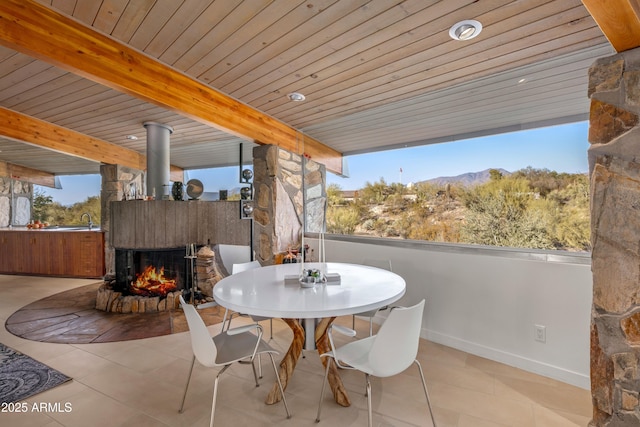 exterior space featuring a multi sided fireplace, a mountain view, and sink