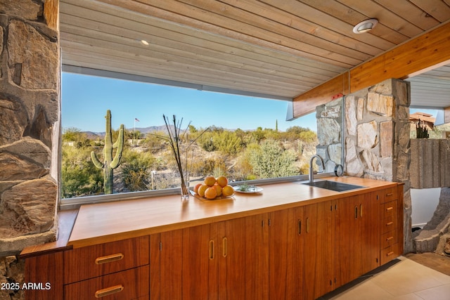 kitchen with beam ceiling, sink, wood ceiling, and light tile patterned floors