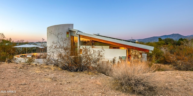 property exterior at dusk with a mountain view