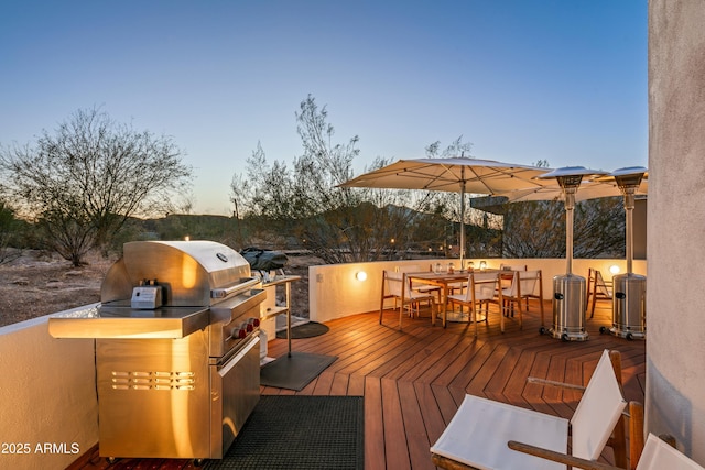 deck at dusk with area for grilling