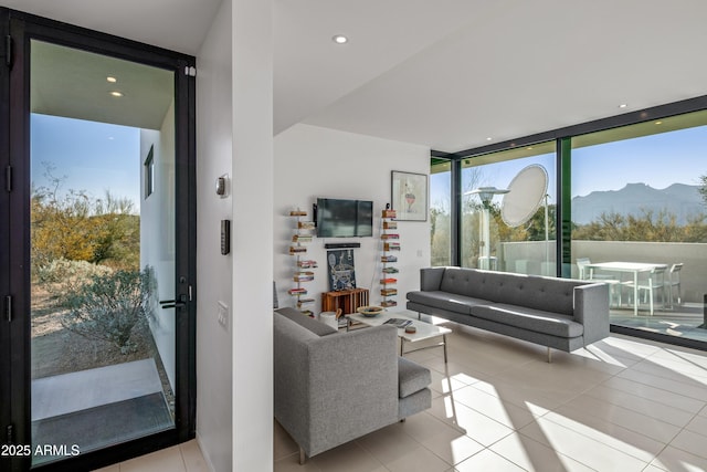 living room with a wall of windows, plenty of natural light, and light tile patterned floors