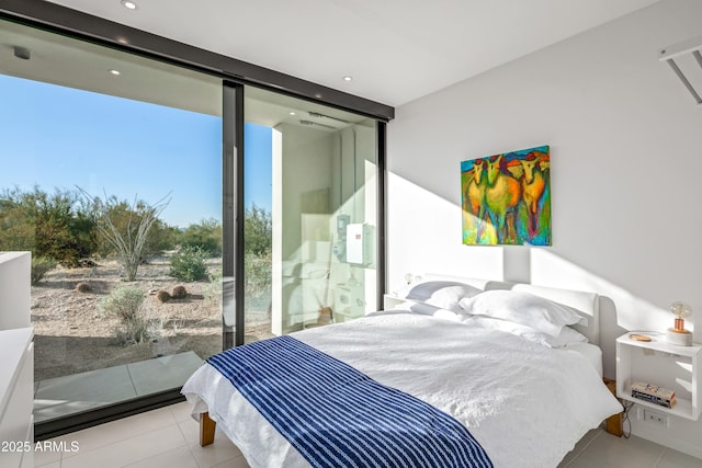 bedroom featuring light tile patterned floors and a wall of windows