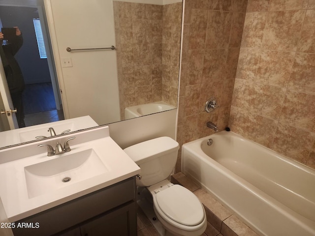 full bathroom with tiled shower / bath, vanity, and toilet