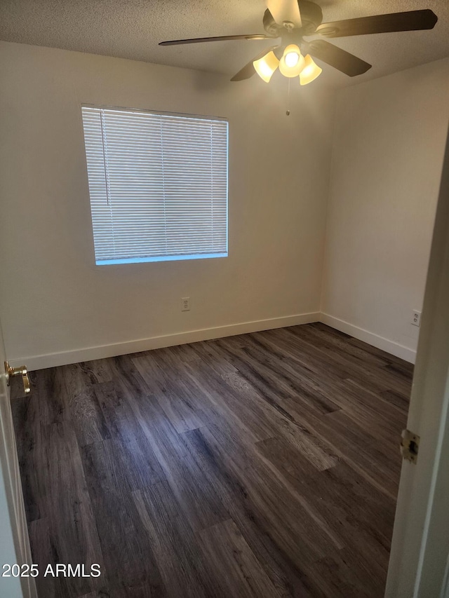 empty room with ceiling fan, dark hardwood / wood-style floors, and a textured ceiling