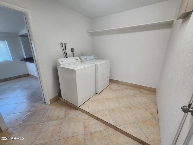 washroom featuring light tile patterned floors and washing machine and clothes dryer