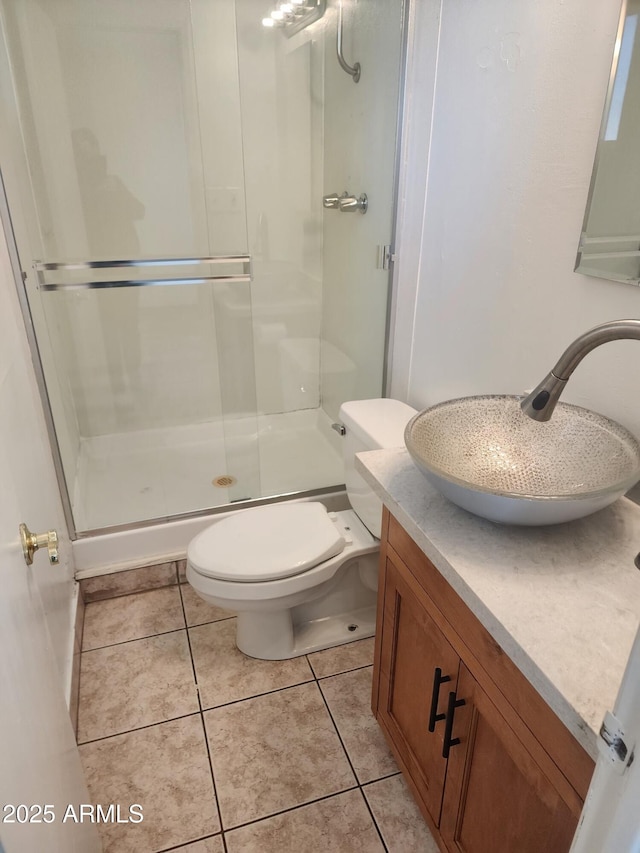 bathroom with tile patterned flooring, vanity, a shower with door, and toilet