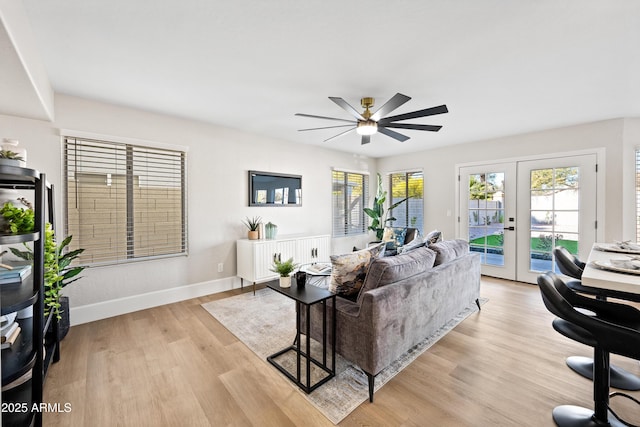 living room featuring ceiling fan, french doors, and light wood-type flooring