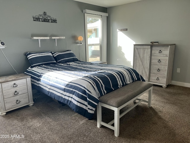 bedroom with dark carpet and baseboards