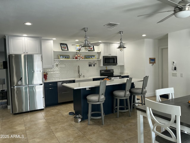 kitchen with visible vents, stainless steel appliances, a sink, and light countertops