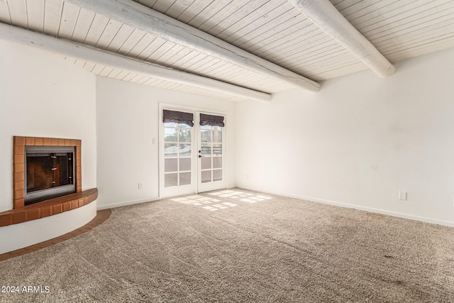 unfurnished living room with carpet, beam ceiling, and a tile fireplace