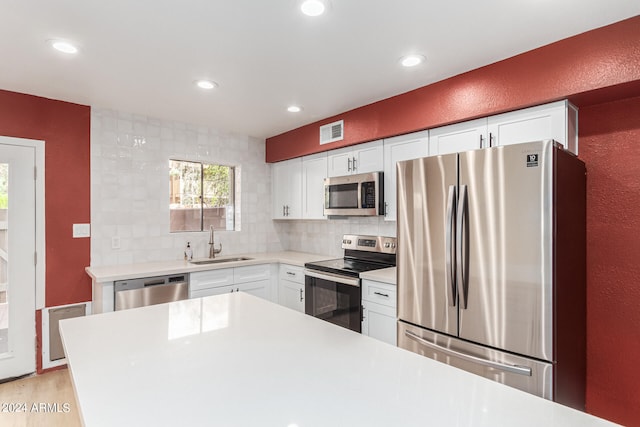 kitchen featuring white cabinets, tasteful backsplash, and stainless steel appliances