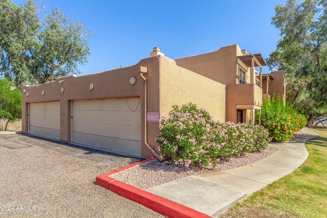 view of side of property with a garage and a balcony