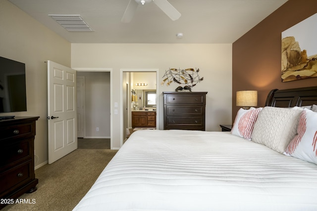 carpeted bedroom featuring baseboards, ensuite bath, visible vents, and a ceiling fan