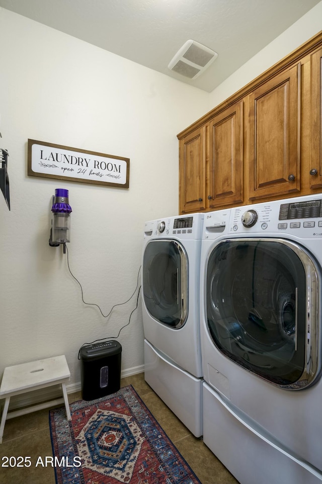 laundry room with visible vents, separate washer and dryer, cabinet space, and tile patterned floors