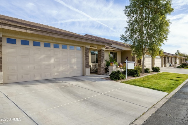 view of front of home with a garage, a front yard, concrete driveway, and stucco siding