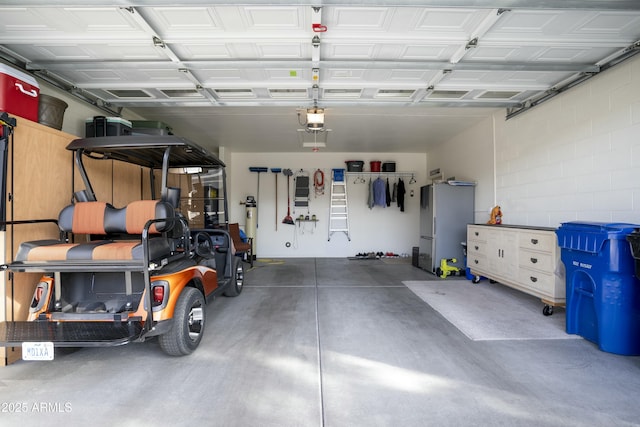 garage featuring concrete block wall and a garage door opener