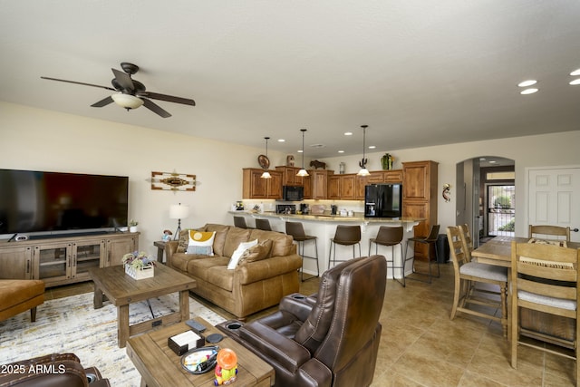 living area with arched walkways, light tile patterned floors, ceiling fan, and recessed lighting