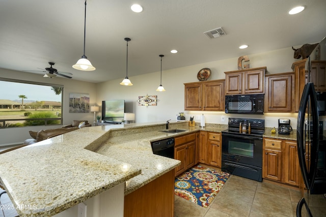 kitchen with visible vents, hanging light fixtures, a sink, a peninsula, and black appliances