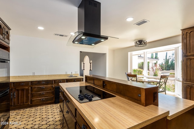 kitchen with sink, exhaust hood, dark brown cabinetry, and black appliances