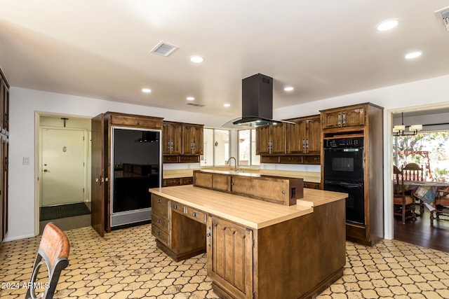 kitchen with dark brown cabinets, double oven, a kitchen island, and island range hood