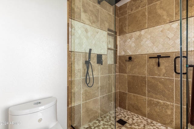 bathroom with toilet and a shower with shower door