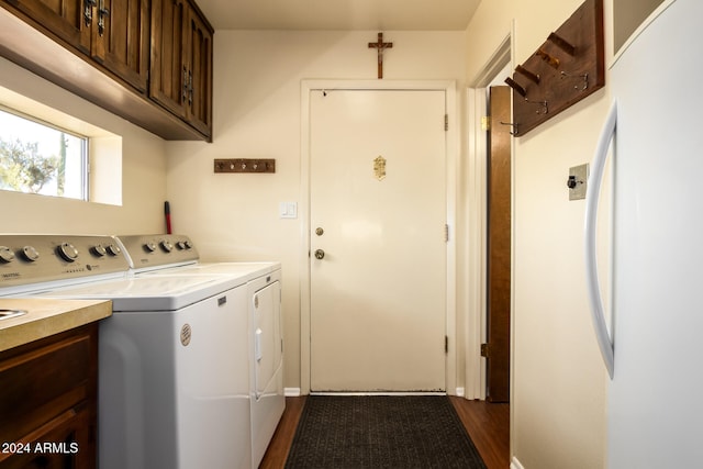 laundry area featuring cabinets, washing machine and clothes dryer, and dark hardwood / wood-style flooring