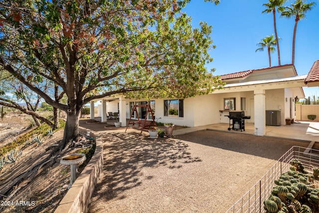 rear view of house with central air condition unit and a patio area