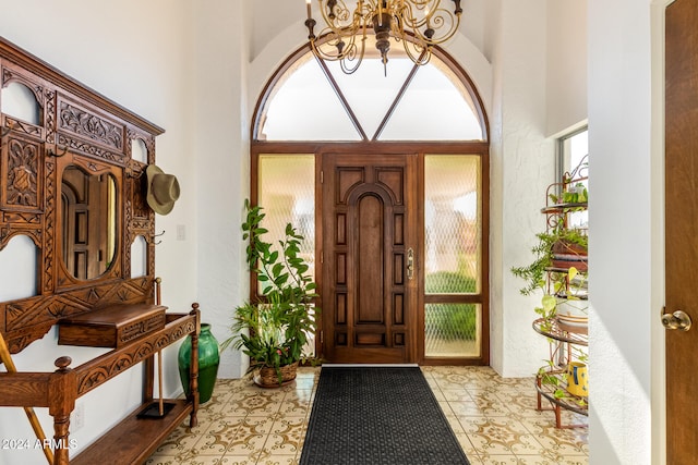 tiled entrance foyer featuring a towering ceiling and an inviting chandelier