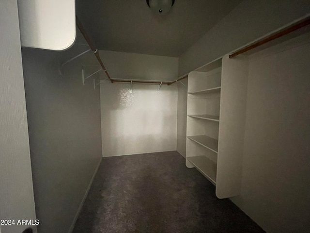 spacious closet featuring dark carpet